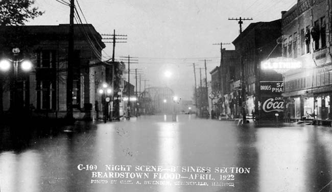 Postcard photograph of a night scene of the business district of Beardstown, Illinois during the flood of 1922