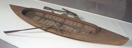 <b>Dan Kidney Duck Boat</b><br>Manufactured by the Kidney & Son Boat Factory, DePere, Wisconsin<br>Cedar wood, canvas<br>beam 3 inches, length 14 feet, weight 100 pounds<br>Double action oars by F. A. Allan, Monmouth, Illinois.  Patent December 1884 and 1888.<br>Illinois State Museum Collection (1990.66.1a-e)<br>Gift of the family of William W. Watson, Barry, Illinois.