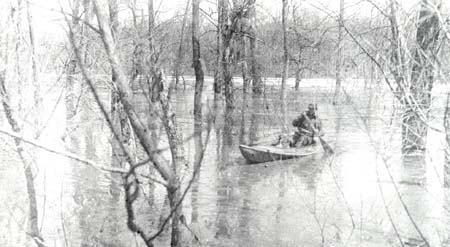<b>Morning Duck Hunt</b>, circa 1903 -1920.<br>Caption reads "Approximately 7000 Acres under water in the Indian Creed and Mills Slough area.  No dry ground within 2 miles of us.  Mail and drinking water from LaGrange Locks (2 mi.)."<p>Note the live decoy in the bow of the boat, a practice which was outlawed in 1935.