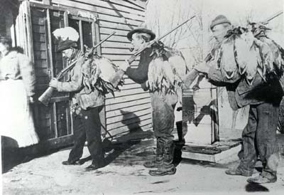 <b>Three Hunters at Day's End</b>.  Hunters carry their ducks strung over the barrels of their rifles, and a cat hitches a ride.