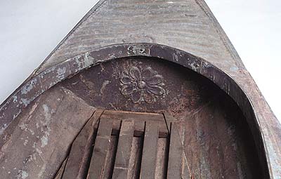 <b>Metal Duck Boat, Detail of Bow</b>.<br>  W. H. Mullins Boat Company, Salem OH, 1893-1924.<br>Elder family, Osbornville, Illinois<br>Galvanized steel<br>12 feet long<br>Illinois State Museum Collection (1992.20)<br>Donated by William Taylor, Decatur, Illinois.<p>Note raised floral decoration in the bow of the boat.