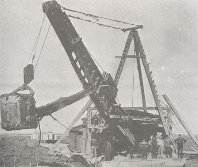 <b>Floating Dredge</b>, 1908.  While on the job, the workmen lived in the houseboat seen in the background.