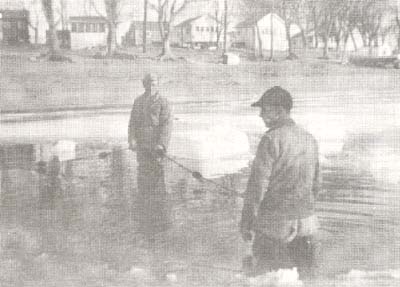 <b>Seining Under the Ice</b>, circa 1940s.  The ice was "thick enough to drive a car across".  Pictured are Charles Hall and Frank Crews.