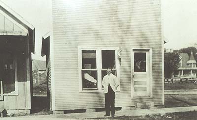 <b>Browning, 1915</b>.  Issac Himmel in front of his barber shop with the John H. Kelly home behind, to the right.