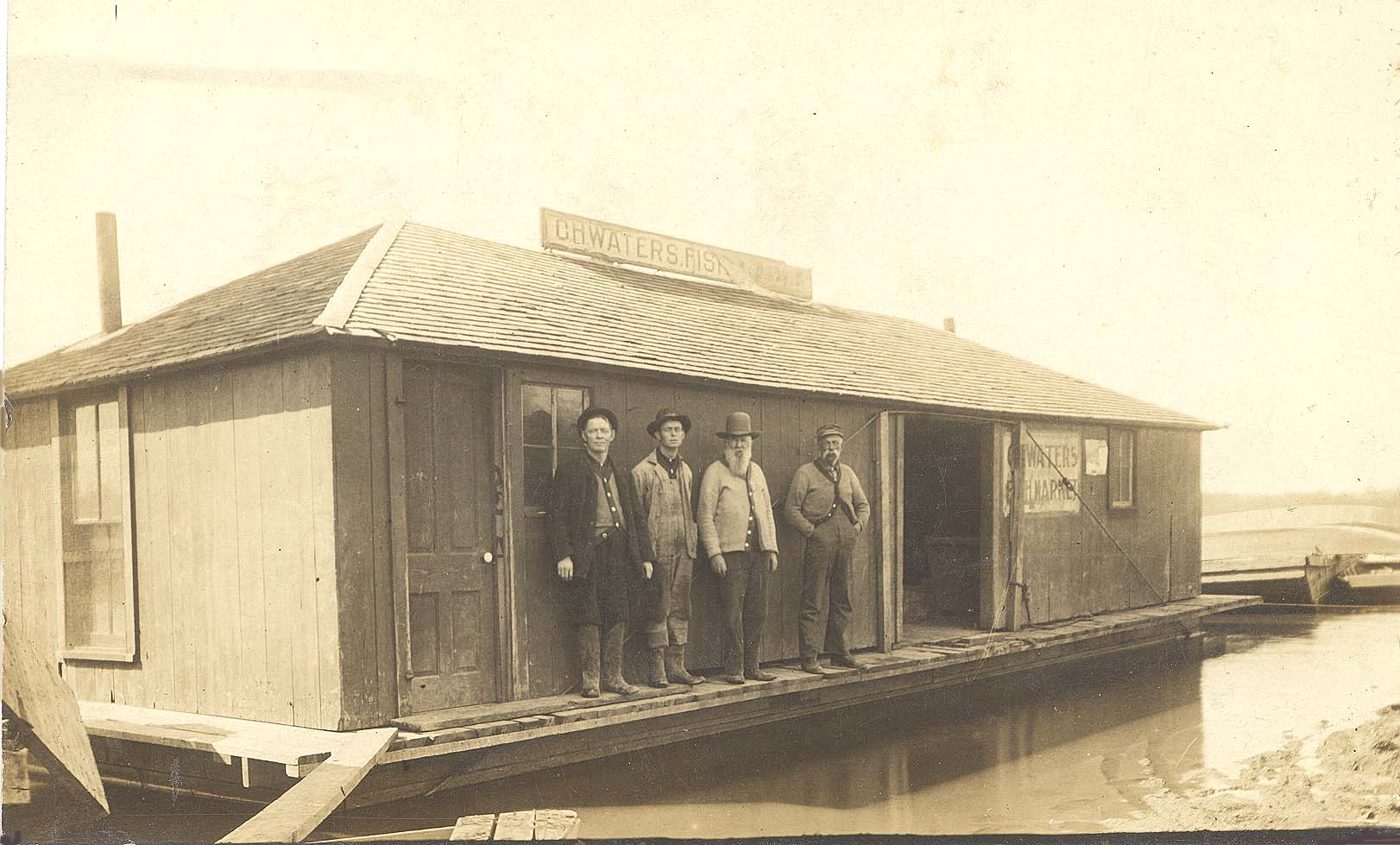 <b>Waters Fish Market</b>, circa early 1900s.  From left to right, C. H. Waters, Warren Waters, Alfred Zeigler, and John Harris.
