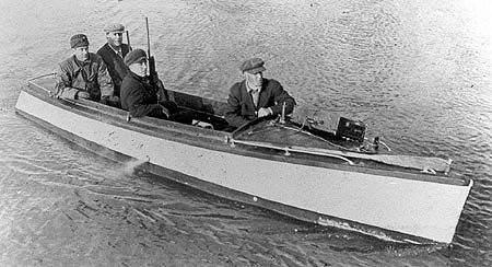 <b>Setting Out for the Blind</b>, circa 1903-1920.  Arthur Dimmitt, Mike Driscoll, Gerald Groves and Fred Hall ride in a launch out to duck blind.