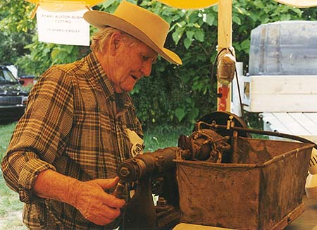 <b>Easley Cutting Button Blanks</b><br>Leonard Easly, of Meredosia, Illinois cuts button blanks from freshwater mussel shell at the 1999 Meredosia Riverfest, Meredosia, Illinois.  He is turning a shell 