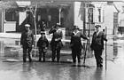 <B>High water in Beardstown</B> in this undated photograph (possibly 1922). People are carrying poles to guide them through any deep spots in the water as they cross flooded roads.