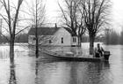 <B>Flooded out resident</B> using his skiff and Mercury outboard to negotiate the flood waters near Beardstown, Illinois (undated)