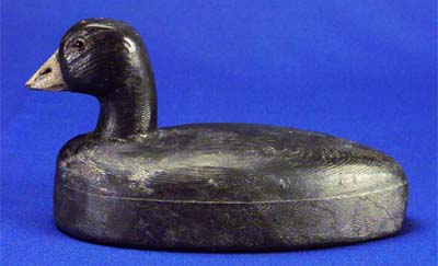 <b>Coot decoy</b>, circa 1920s. <br> Made by Guy Lukeman, South Pekin, Illinois. <br> White pine or cedar, 5 3/4 inches high by 10 3/4 inches long.<br>Illinois State Museum Collection (1967.17, 798958)  <br>Gift of Phyllis Lukeman.  <p>Guy Lukeman (1883-1945) made about 100 decoys in his lifetime for his own use.  He appropriated and adapted patterns by the Herter Company of Watseka, Minnesota, and often used Herter paints.  He also mixed his own colors and painted his decoys in a simple, direct style.