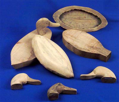 <b>Carved parts of wooden decoys</b>.<br>Clockwise from the top right:  Lower body, hollowed out; rough cut pattern, 2