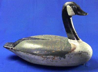 <b>Canada Goose Decoy</b>, circa 1890.<br>  Made by Charles Whitmore.<br>White pine, 14 3/4 inches high by 21 1/2 inches long.<br>Illinois State Museum COllection (1971.16, 798832) <br>Gift of Joseph French, St. Louis, Missouri. <p>Charles Whitmore was a market hunter and boatmaker in New Boston, Illinois, on the Mississippi River south of Muscatine, Iowa.  A few examples of his decoys remain, including a Canada Goose decoy made in three hollow sections.  It has tacks for eyes and has been repainted.  It is marked 