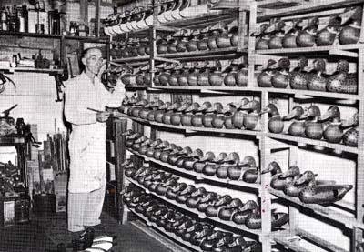 <b>J. Fred Mott, Jr.</b>, in his basement workshop with some of the more than three thousand decoys carved during his lifetime.