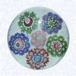 Garland MIllefiori on FiligreeFranceClichy, circa 1845-55Diameter: 7 cm (2 3/4 inches)(702387)Garland millefiori with five circlets in blue, green, purple, and red canes, each containing a single center cane, encircling a central pink circlet with a green center cane; on a white filigree ground backed with parallel lengths of white filigree twists