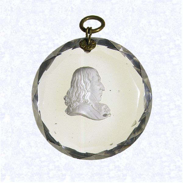 <B>Sulphide Portrait Plaque<BR>France<BR>Baccarat (attributed), circa 1830</B><BR>Diameter: 6 cm (2 3/8 inches)<BR>(702486)<BR><BR>Circular clear glass plaque with faceted edges, enclosing a sulphide profile portrait of a man, possibly French mathematician Blaise Pascal (1623-1662); gilded metal ring and collar